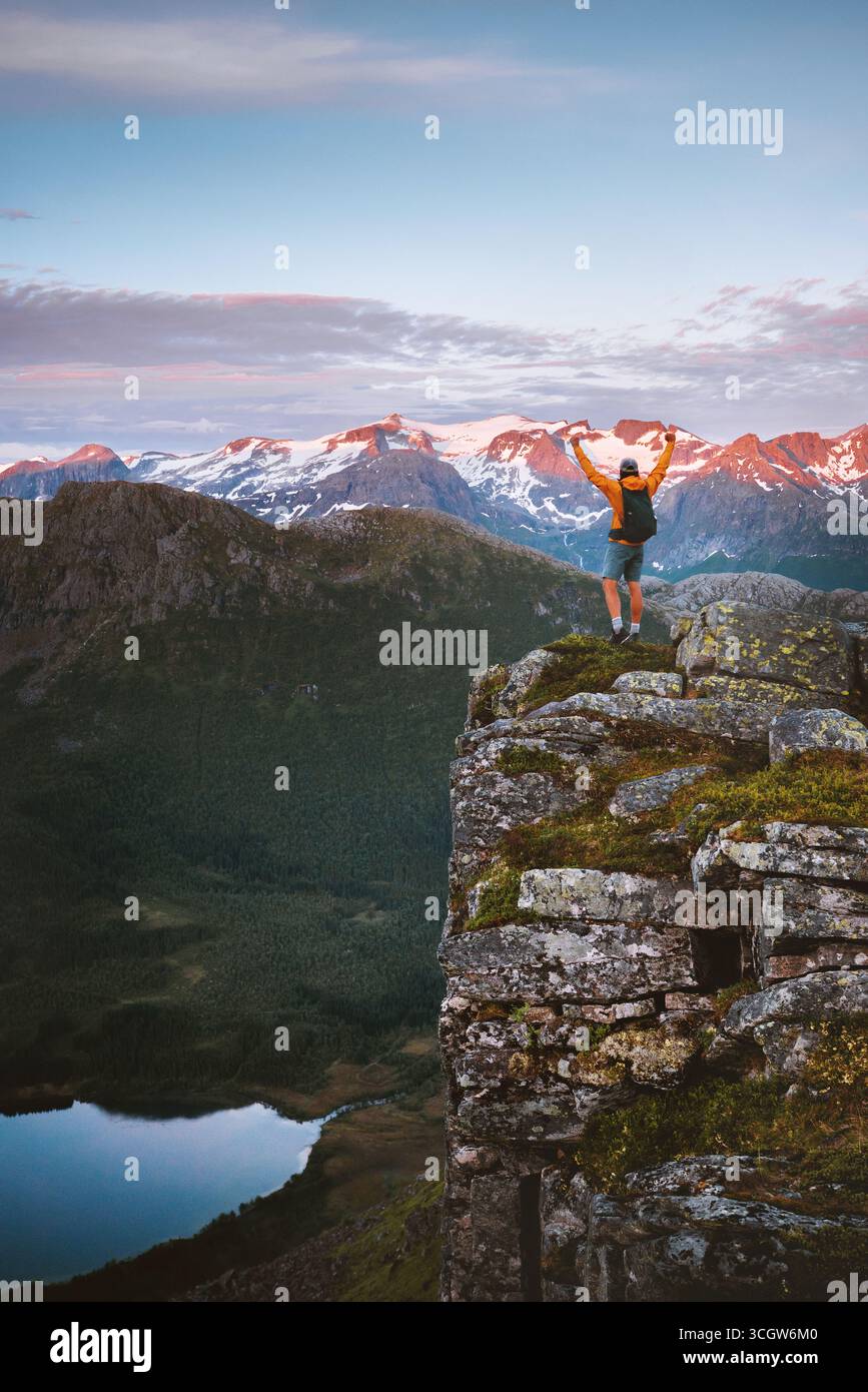 Homme voyageur randonnée solo en Norvège debout sur le bord de falaise profitant des montagnes de coucher du soleil et vue sur le lac, voyage aventure voyage dans la nature avec nat paisible Banque D'Images