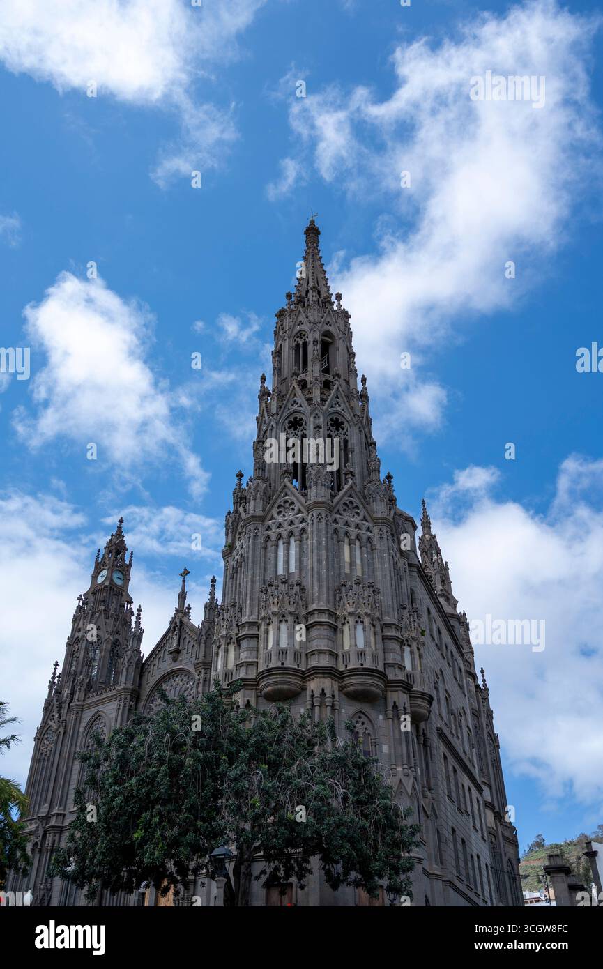 Un grand bâtiment avec un clocher et une tour de l'horloge. Le ciel est bleu et il y a des nuages en arrière-plan Banque D'Images