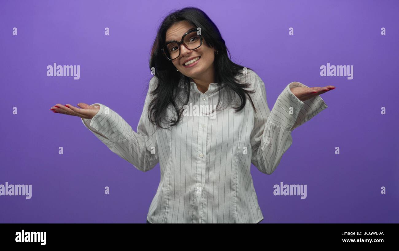 Femme souriante haussant les paumes des mains portant des lunettes dans le studio ; incertitude doute hésitation confusion. Banque D'Images