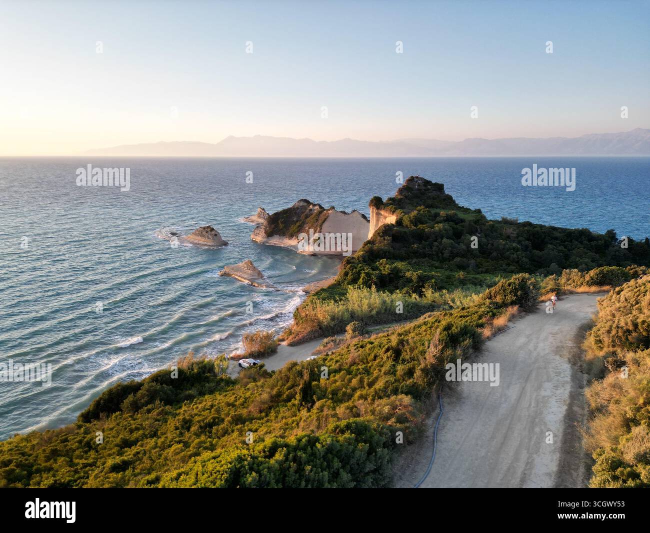 La vue imprenable sur le cap Drastis sur l'île de Corfou, avec l'Albanie en arrière-plan, pendant l'heure d'or. Banque D'Images