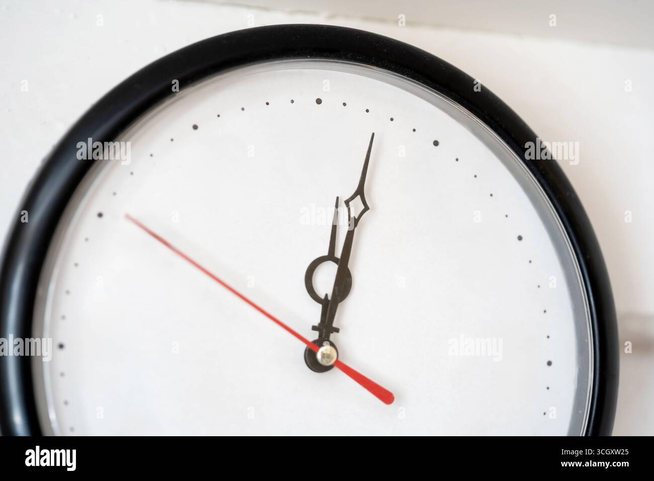 Horloge murale minimale sans chiffres, cadran analogique avec aiguilles noires rouge seconde main sur vide face blanche vierge avec marqueurs à points gros plan gestion du temps fl Banque D'Images