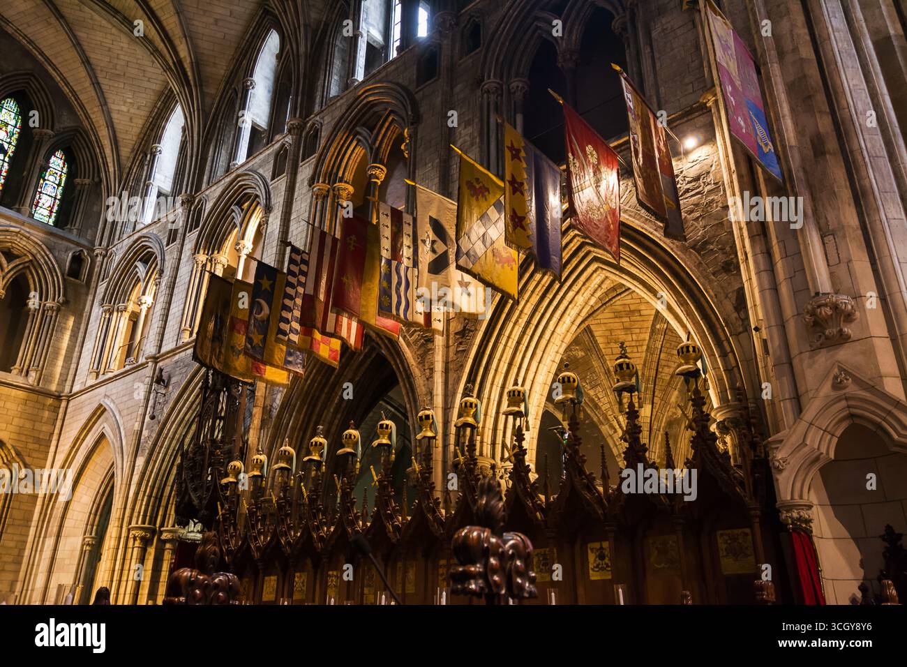 Intérieur de la cathédrale St Patricks à Dublin Irlande avec des plafonds voûtés et des drapeaux colorés décorant l'église historique Banque D'Images