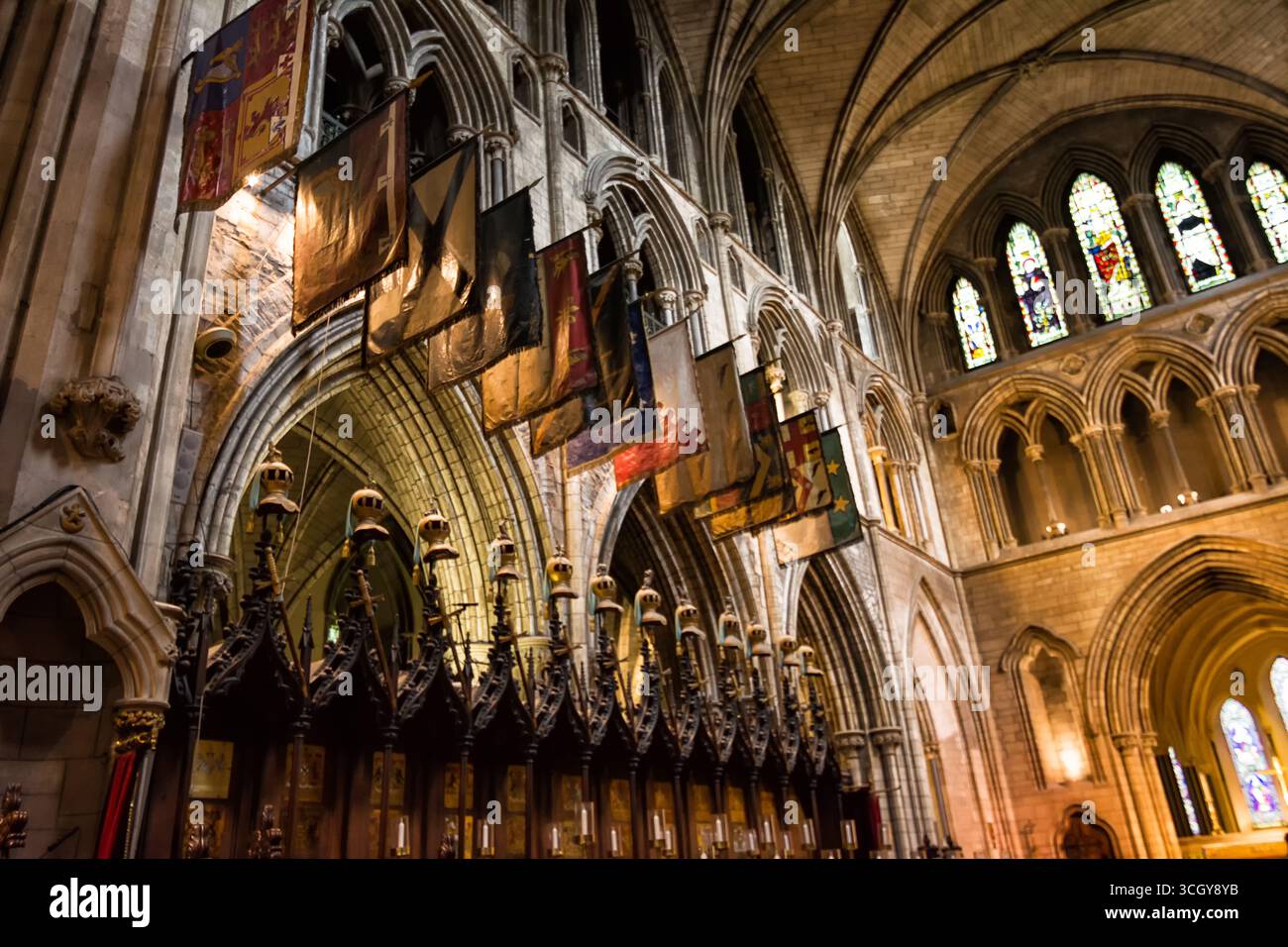 Intérieur de la cathédrale St Patricks à Dublin Irlande avec des plafonds voûtés et des drapeaux colorés décorant l'église historique Banque D'Images