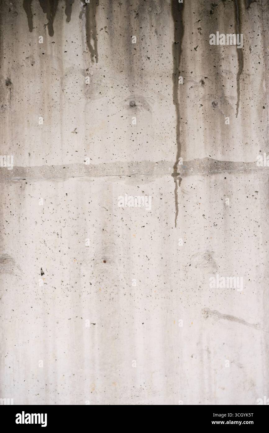 L'eau coule le long d'un mur de béton dur, créant un contraste saisissant avec les éclaboussures rouges éclatantes. Idéal pour les thèmes urbains et les visuels dramatiques Banque D'Images