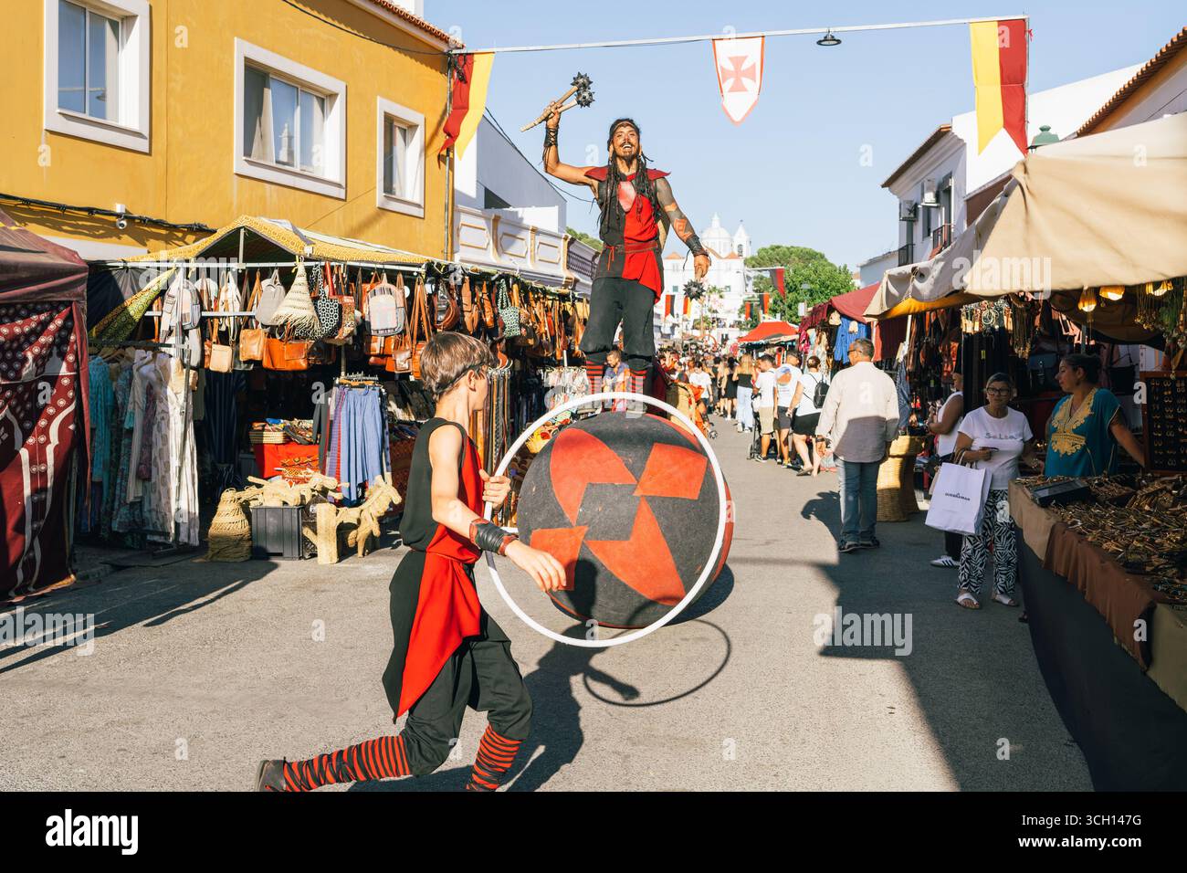 Castro Marim, Portugal, 29 août 2025. Un acrobate costumé divertit la foule en s'équilibrant sur un bal décoré à la foire médiévale. Banque D'Images