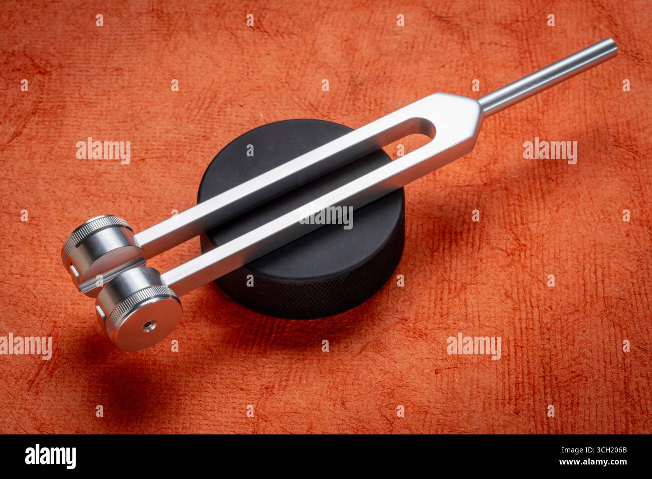 Diapason pondéré en métal utilisé pour accorder des instruments de musique, la thérapie du son, la guérison ou la relaxation du chakra, l'activateur de palets de hockey. Banque D'Images