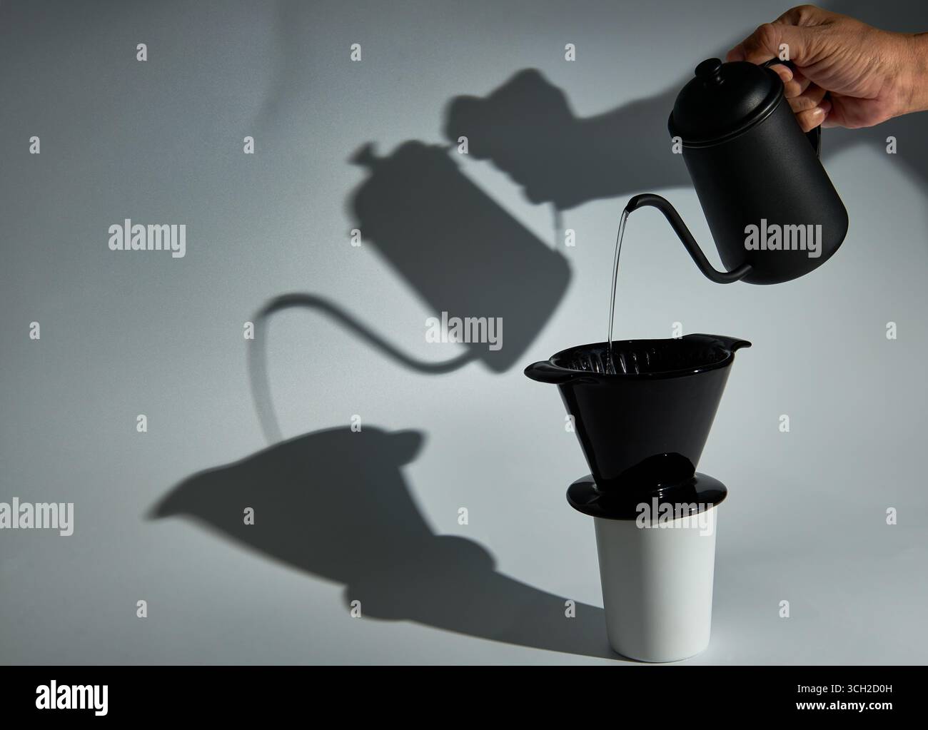 Une nature morte minimaliste et artistique du processus de préparation du café à verser, avec une ombre forte et graphique. Un concept pour le café artisanal, la précision, un Banque D'Images