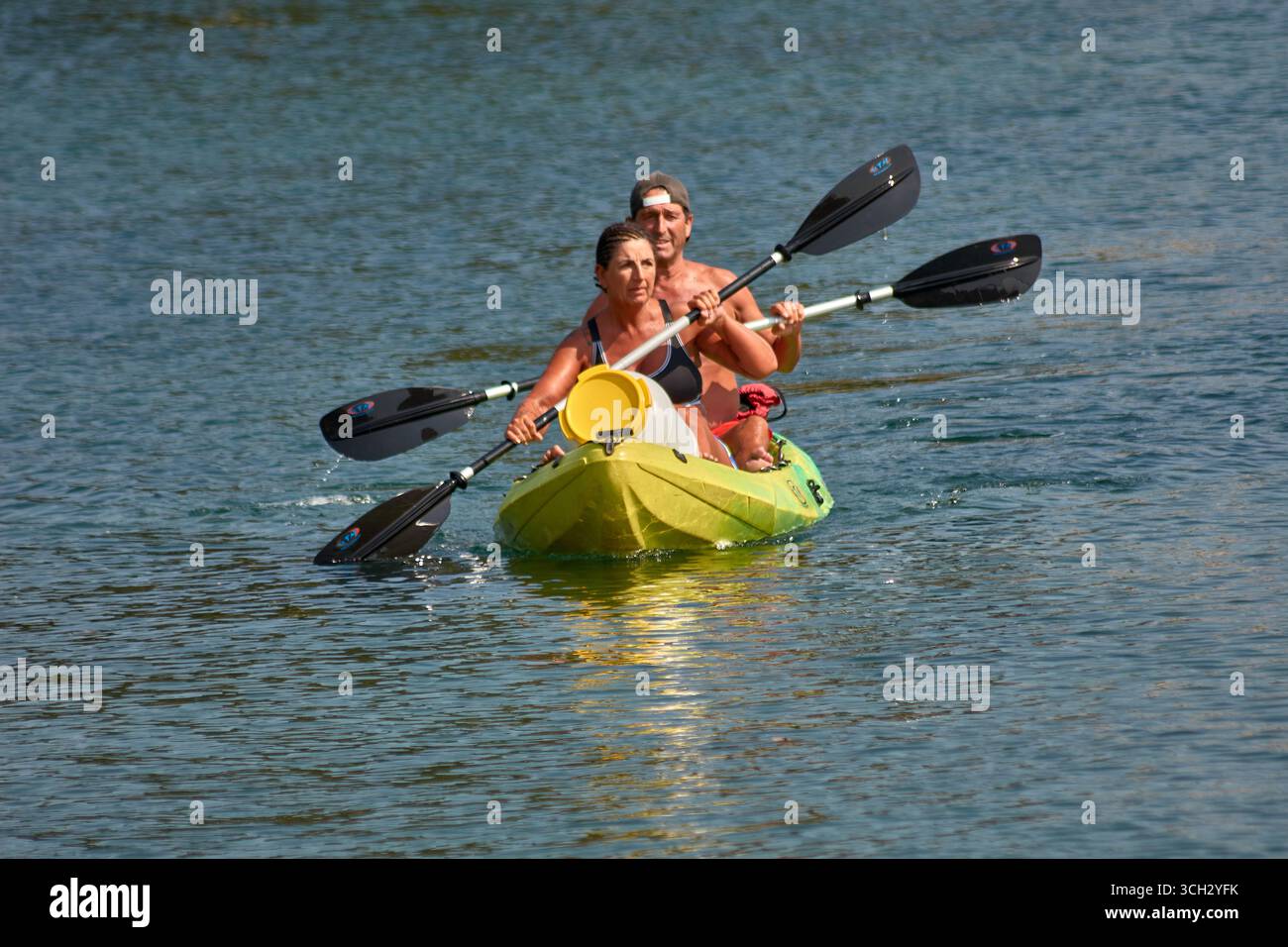 Nigran, Pontevedra, Espagne;24 août 2025:deux personnes pagayent un canoë jaune sur les eaux calmes de l'estuaire A Foz à Ramallosa, Nigran sur un summe ensoleillé Banque D'Images