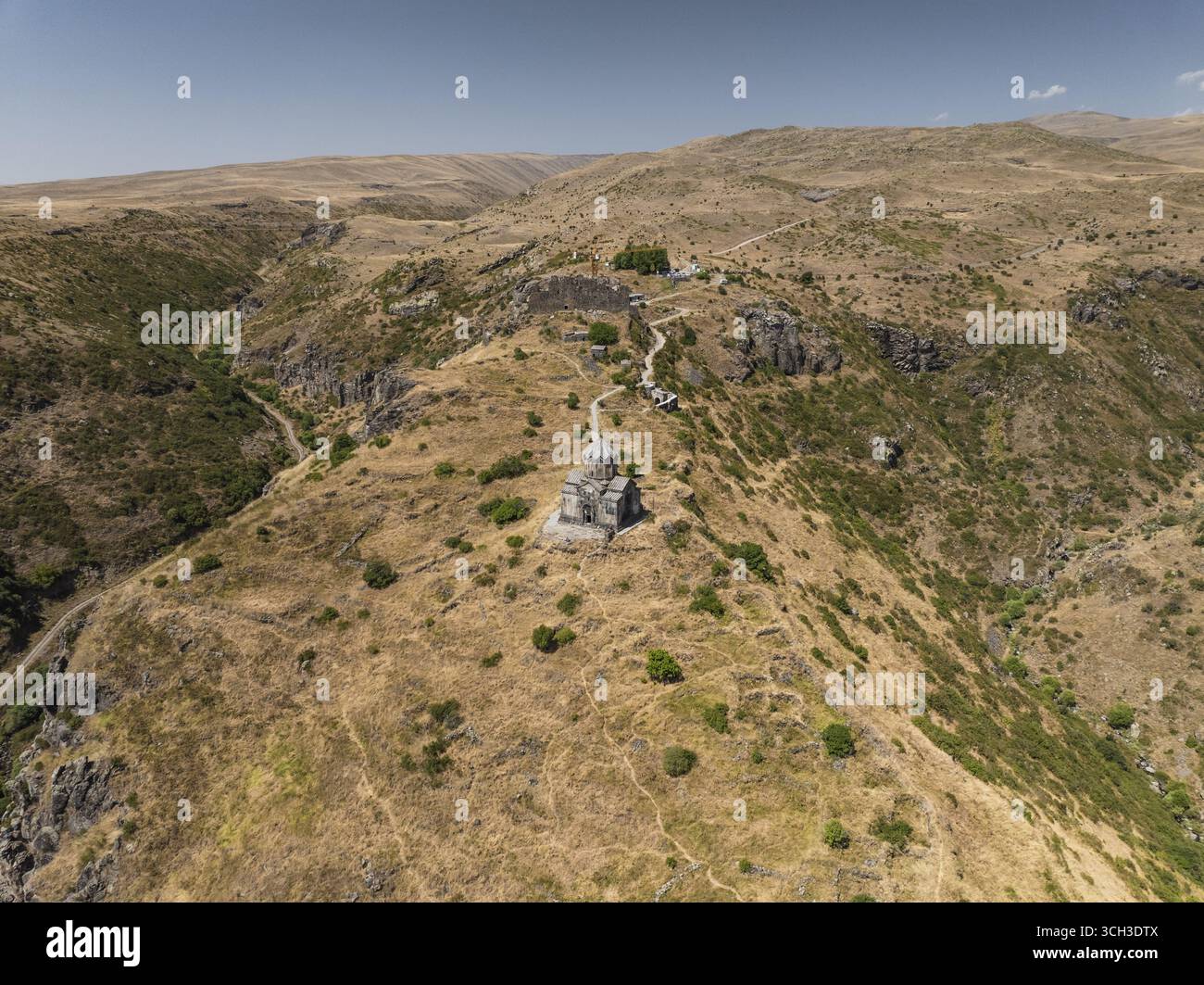 Vue aérienne de l'ancienne église de Vahramashen perchée au sommet d'une colline, sa pierre contrastant avec le paysage aride sous un vaste ciel, église de Vahramashen, province d'Aragatsotn, Arménie. Banque D'Images