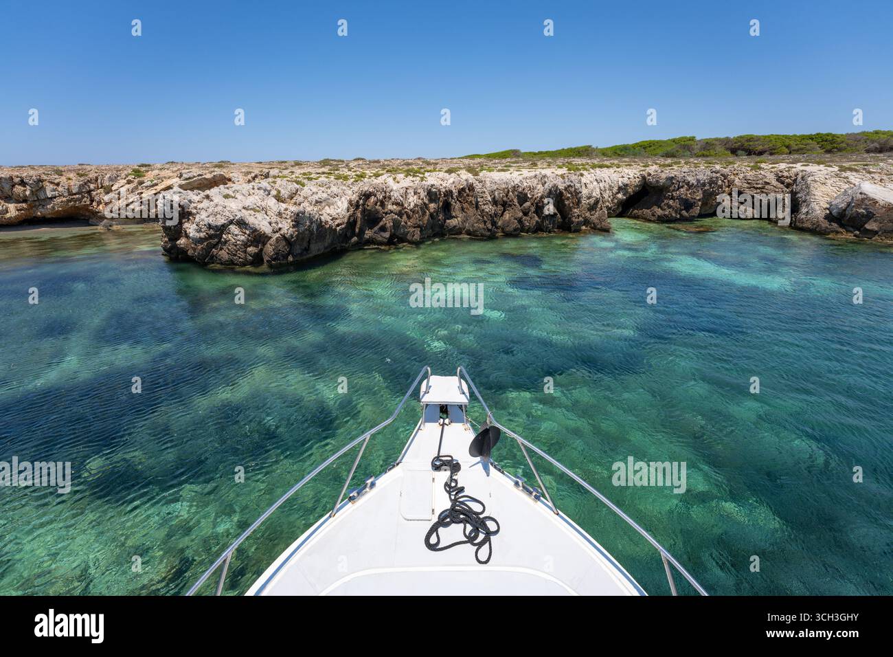 Bateau approche de la côte rocheuse avec une eau turquoise claire à Favignana, Italie Banque D'Images