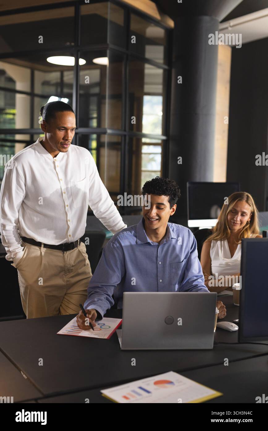 Collaboration dans le bureau moderne, professionnels discutant des détails du projet sur ordinateur portable Banque D'Images Collaboration dans le bureau moderne, professionnels discutant des détails du projet sur ordinateur portable Banque D'Images