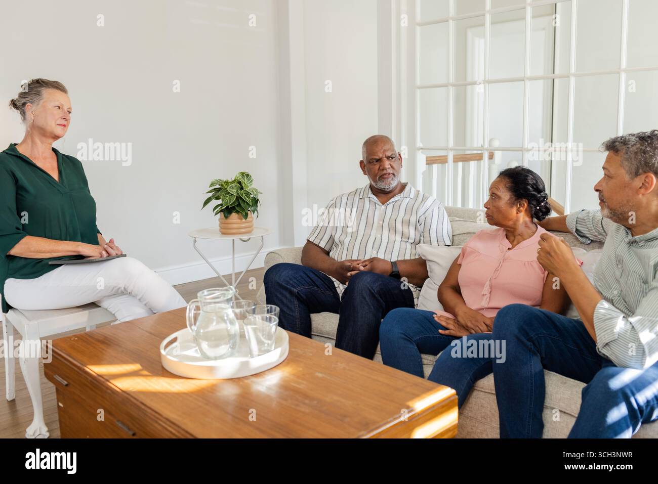 Famille afro-américaine ayant une conversation sincère avec un thérapeute dans le salon Banque D'Images