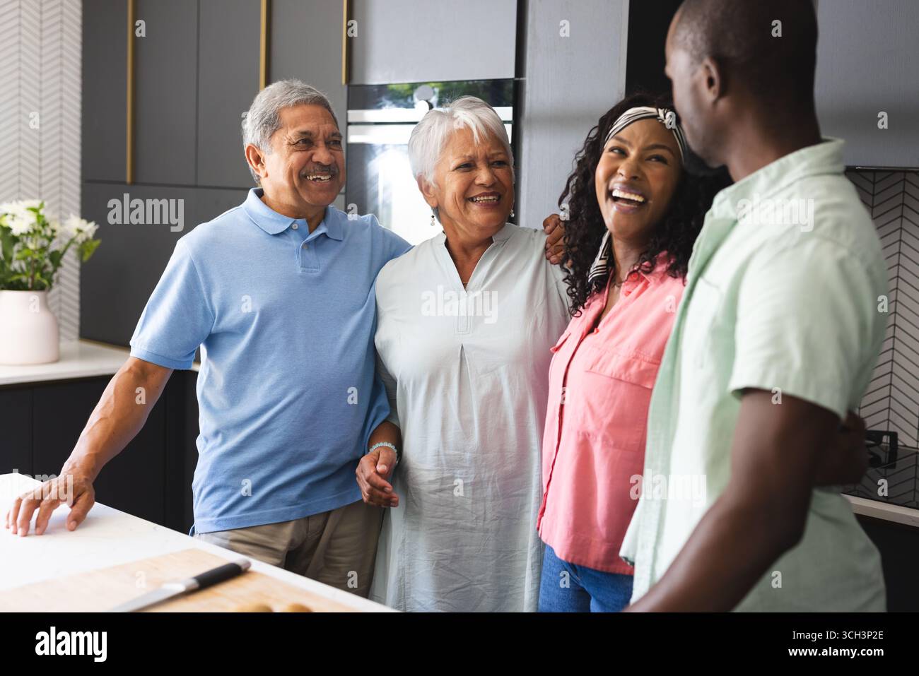 Dans la cuisine, famille multigénérationnelle passer du temps de qualité , souriant chaleureusement, à la maison Banque D'Images Dans la cuisine, famille multigénérationnelle passer du temps de qualité , souriant chaleureusement, à la maison Banque D'Images