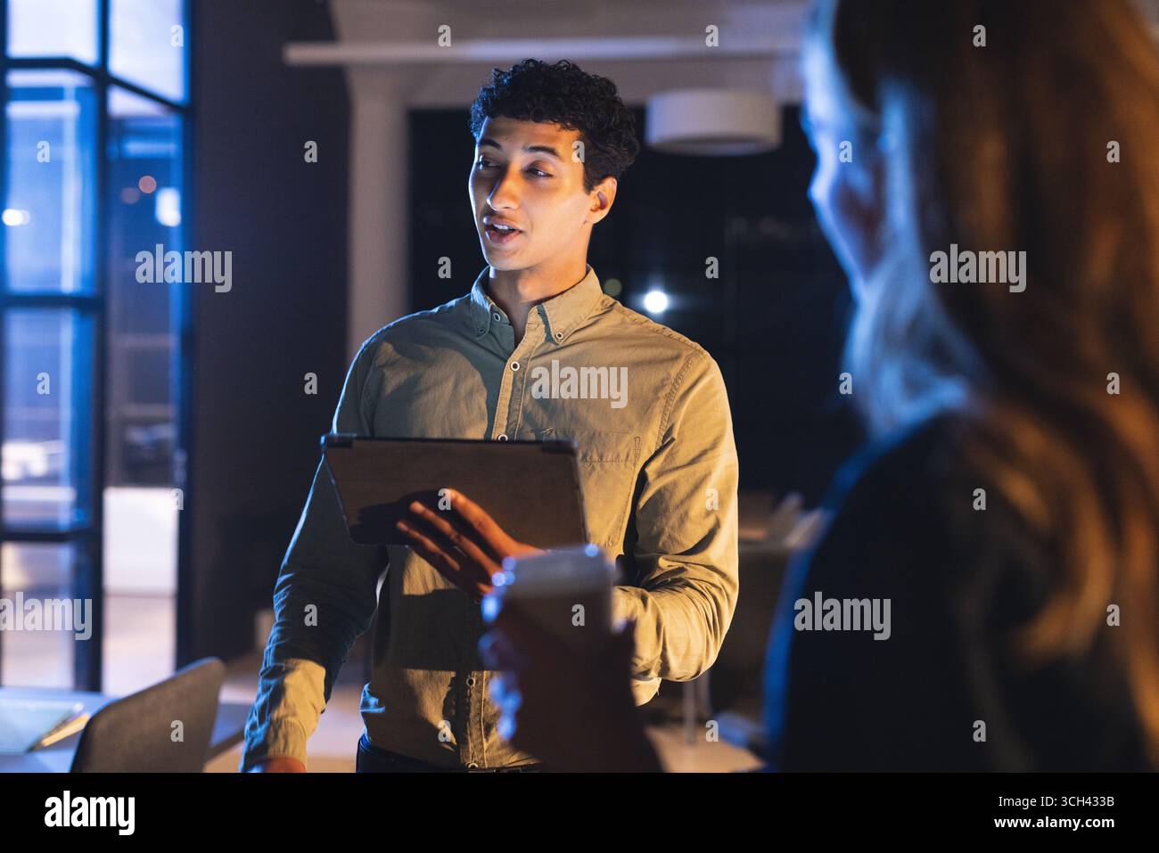 Présentation d'idées sur tablette, homme d'affaires dirigeant la réunion de fin de nuit au bureau Banque D'Images Présentation d'idées sur tablette, homme d'affaires dirigeant la réunion de fin de nuit au bureau Banque D'Images