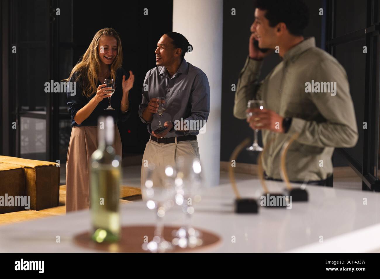 Rassemblement dans un bureau moderne, collègues ayant un verre et conversation le soir Banque D'Images Rassemblement dans un bureau moderne, collègues ayant un verre et conversation le soir Banque D'Images