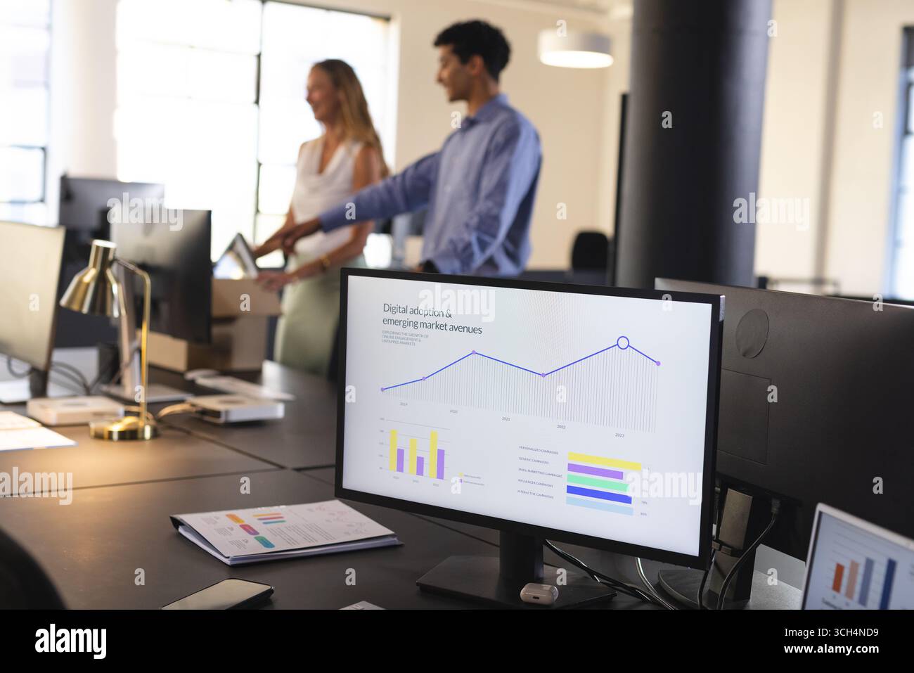 Professionnels des affaires discutant des graphiques de données sur l'écran d'ordinateur dans le bureau moderne Banque D'Images Professionnels des affaires discutant des graphiques de données sur l'écran d'ordinateur dans le bureau moderne Banque D'Images