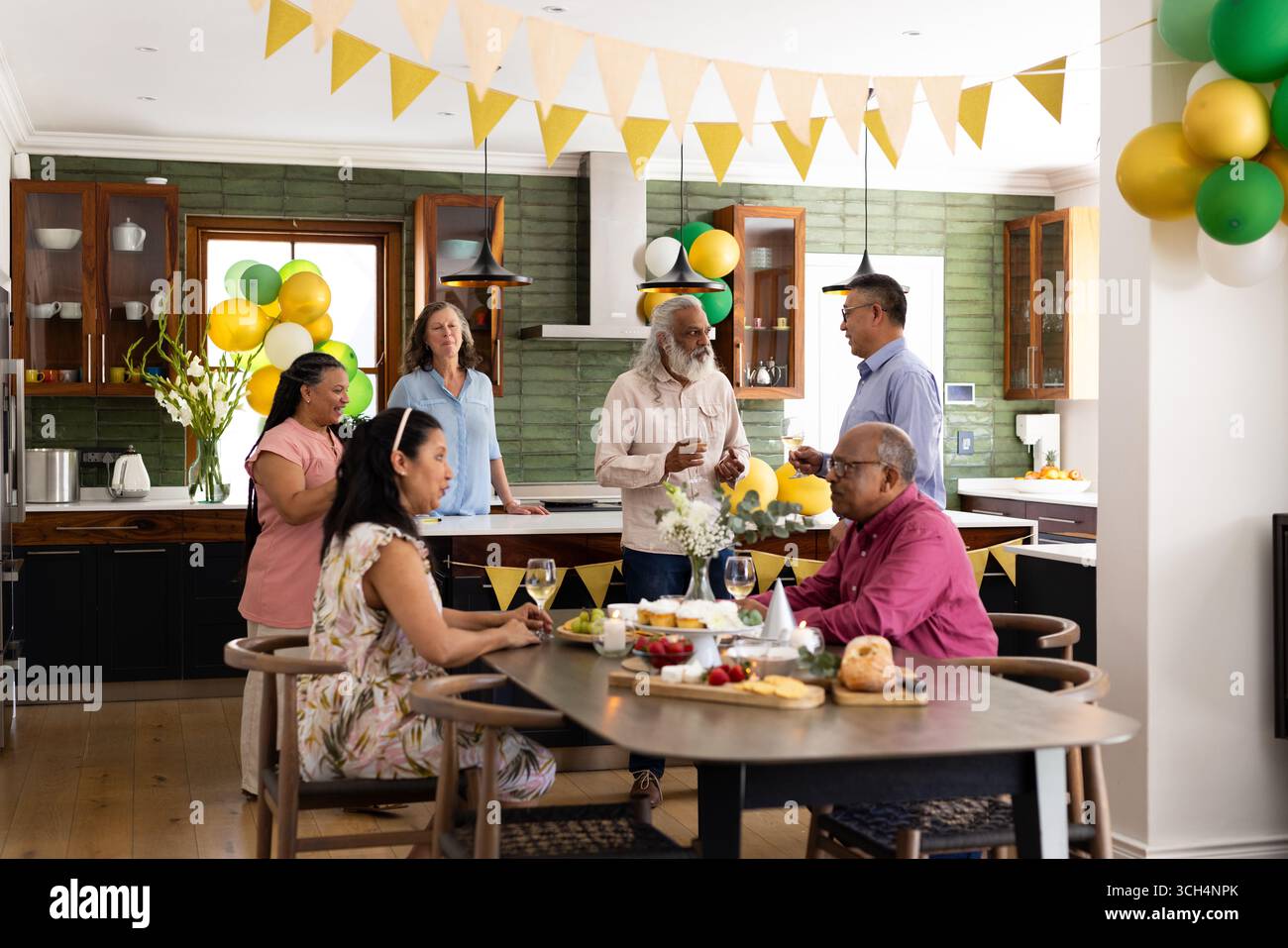 Groupe de personnes âgées appréciant la conversation et les boissons à la maison pendant la fête festive Banque D'Images