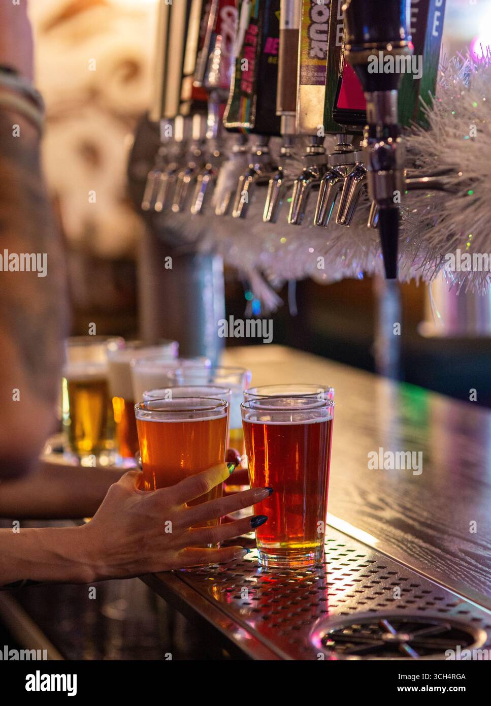 Scène de bar de Noël avec des pintes de bière coulant des robinets festifs Banque D'Images