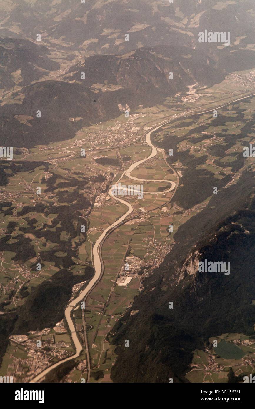 Une rivière serpente à travers une vallée avec un lac d'arc-en-ciel en formation Banque D'Images