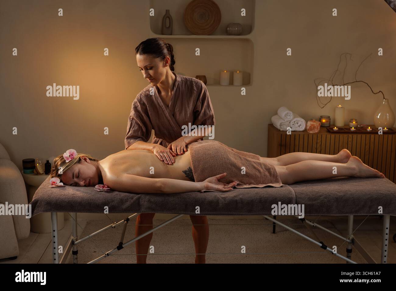 Masseur féminin donne un massage relaxant du dos dans le spa tranquille, idéal pour le bien-être, le soin, la beauté et les thèmes de relaxation. Banque D'Images