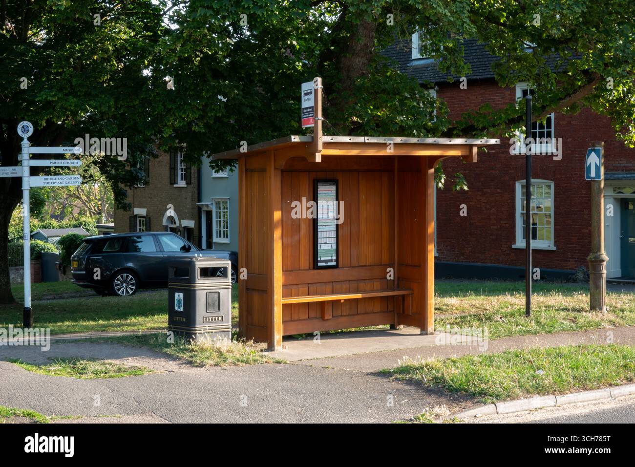 Un arrêt de bus à Saffron Walden, Angleterre. La scène montre un abri de bus en bois avec un banc et un plan d'itinéraire. Banque D'Images