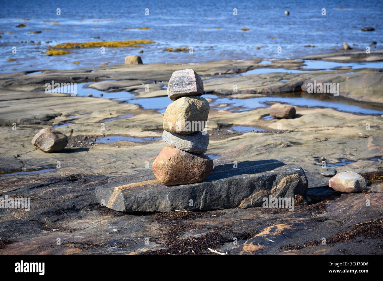Pile rocheuse équilibrée sur le littoral côtier avec l'eau de la mer Blanche en arrière-plan, concept de paysage en pierre et nature de Carélie Banque D'Images