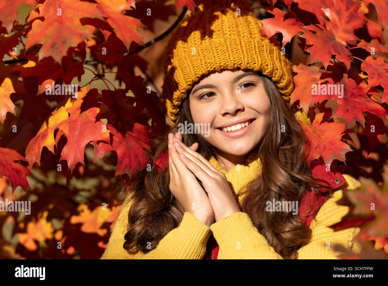 Visage de fille d'enfant d'automne sur fond de feuille d'automne. Automne enfant adolescente fille 12, 13, 14 ans portrait. enfant heureux dans le chapeau debout aux feuilles d'automne Banque D'Images
