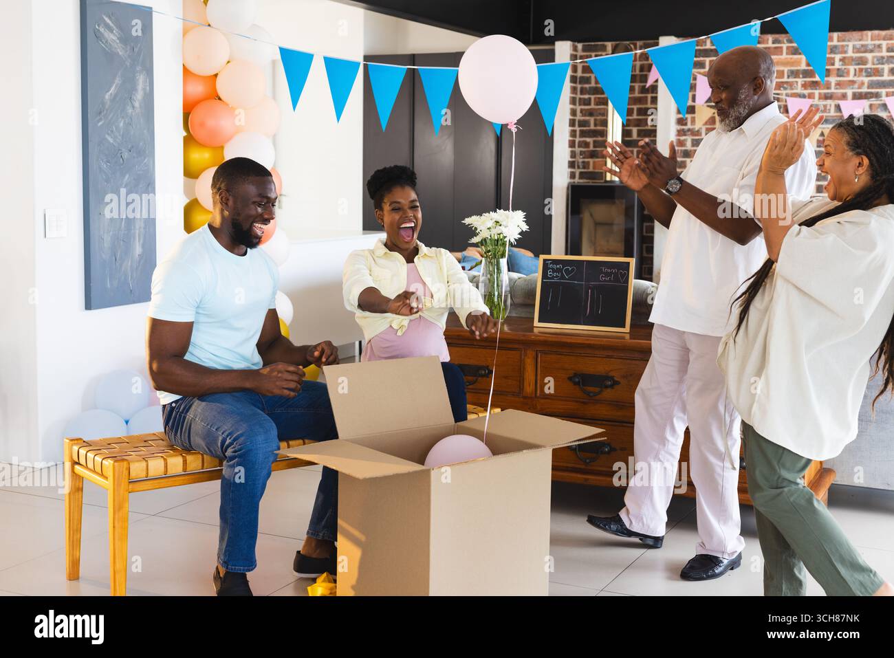 Célébrant Baby Gender Reveal, famille afro-américaine montrant l'excitation et la joie à la maison Banque D'Images