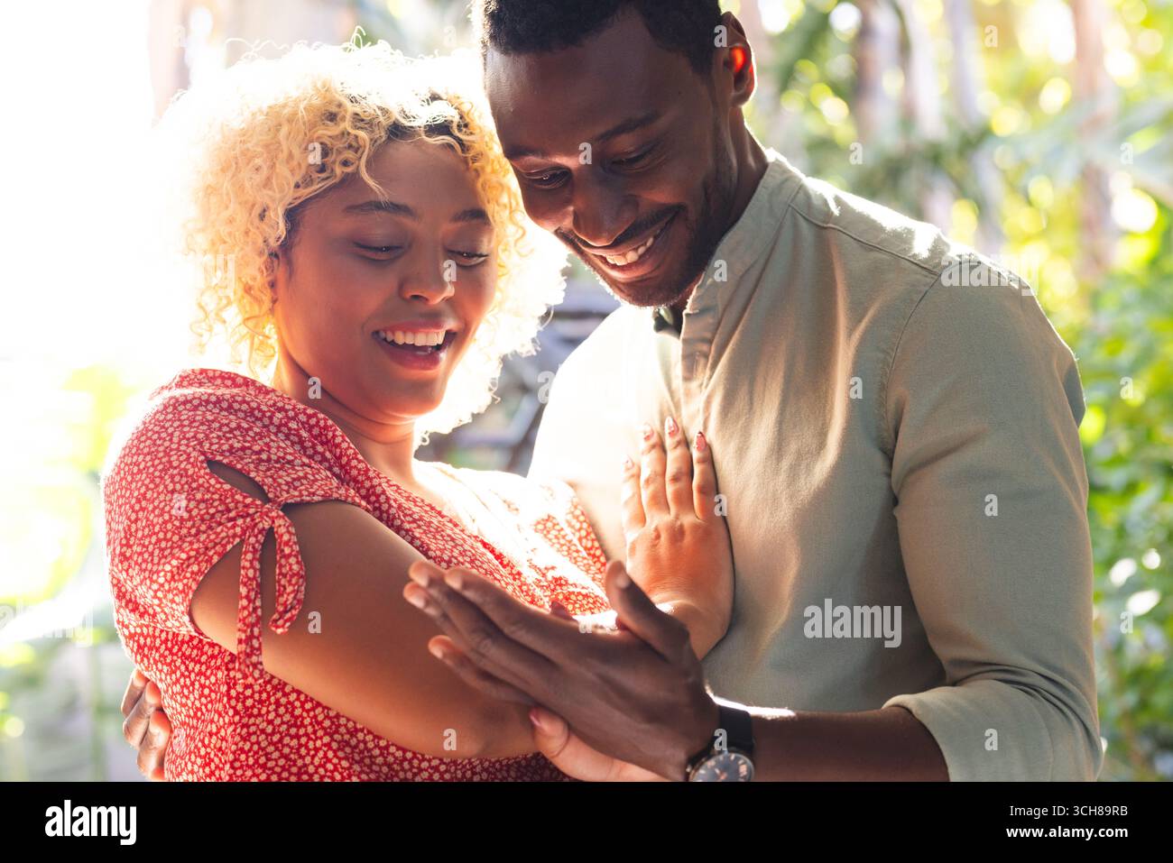 Couple afro-américain riant et profitant d'un moment joyeux ensemble à l'extérieur Banque D'Images