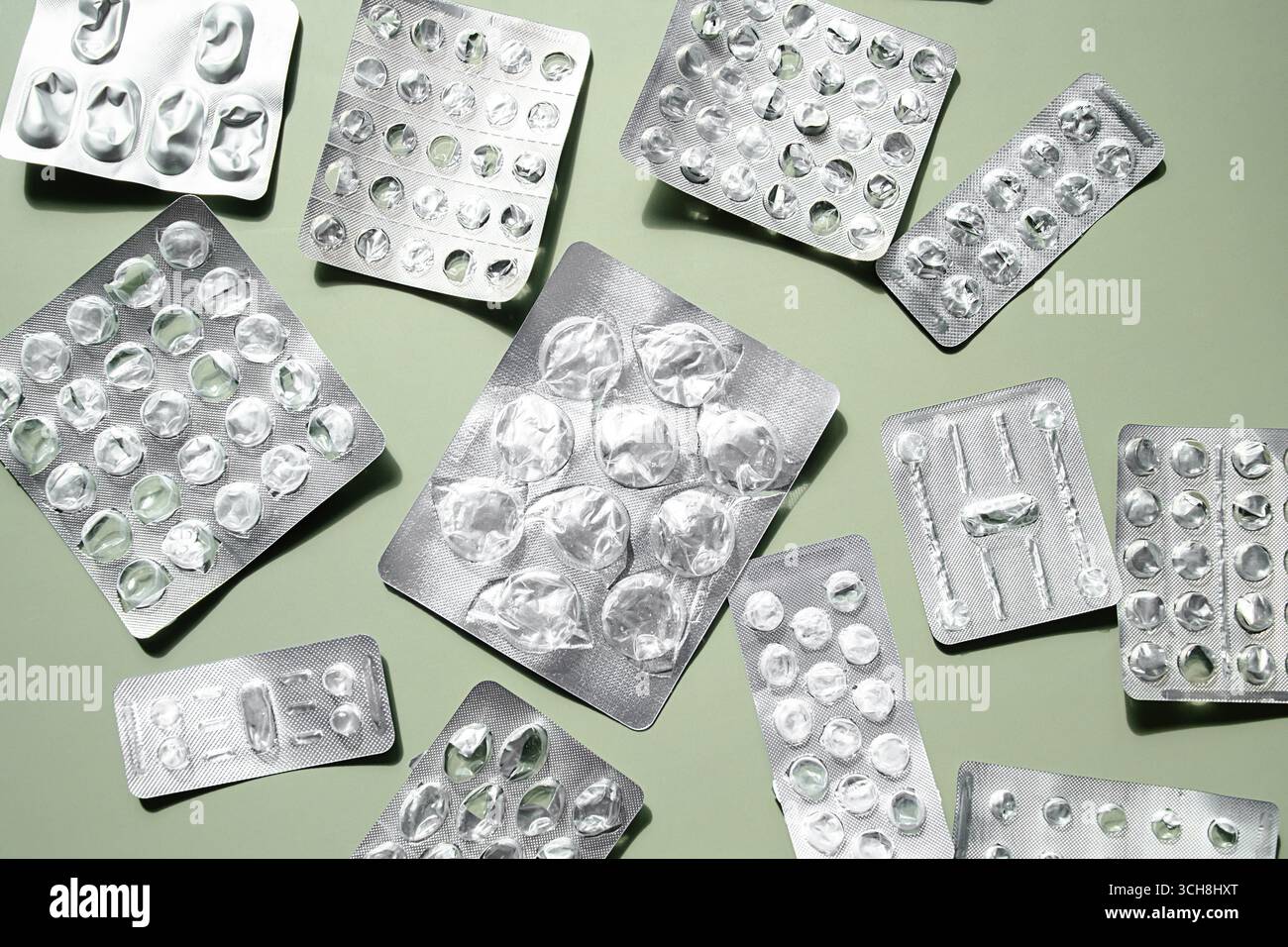 Emballage de blister en aluminium vide sur fond vert clair. Bandelettes de comprimés médicaux usagés. Soins médicaux et concept pharmaceutique. Banque D'Images
