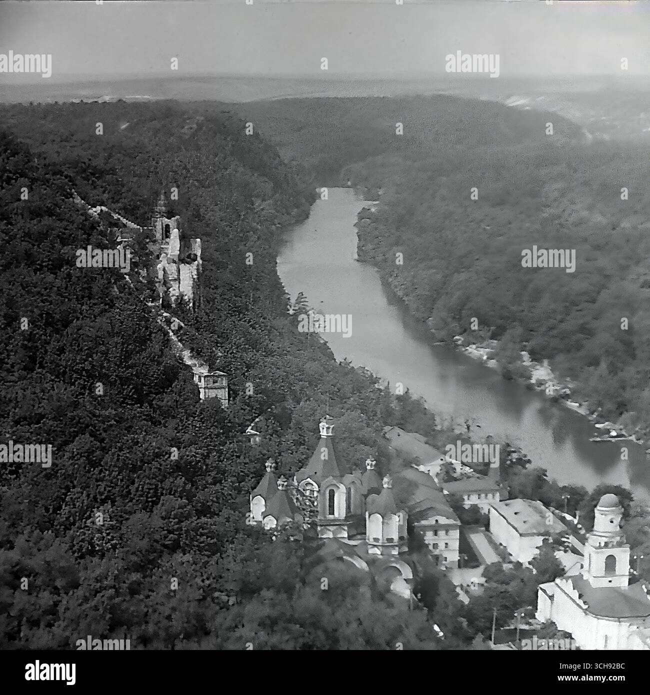 Une vue panoramique majestueuse sur la Lavra de Sviatohirsk et la vallée de la rivière Seversky Donets, prise dans la période d'après-guerre, vers les années 1950 De vieilles tours en ruine partielle peuvent être aperçues à flanc de montagne, témoignant d'une époque antérieure aux restaurations à grande échelle. Cette photo est un document historique précieux, capturant le paysage unique de « Donets Suisse » et véhiculant une atmosphère de renouveau et de tranquillité. C’est un symbole de résilience et de la longue vie paisible du Donbass. Banque D'Images