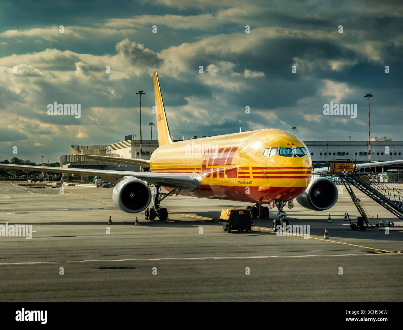 Un avion cargo DHL stationné sur le tarmac sous un ciel nuageux à l'aéroport international de Milan Malpensa en Italie. Banque D'Images