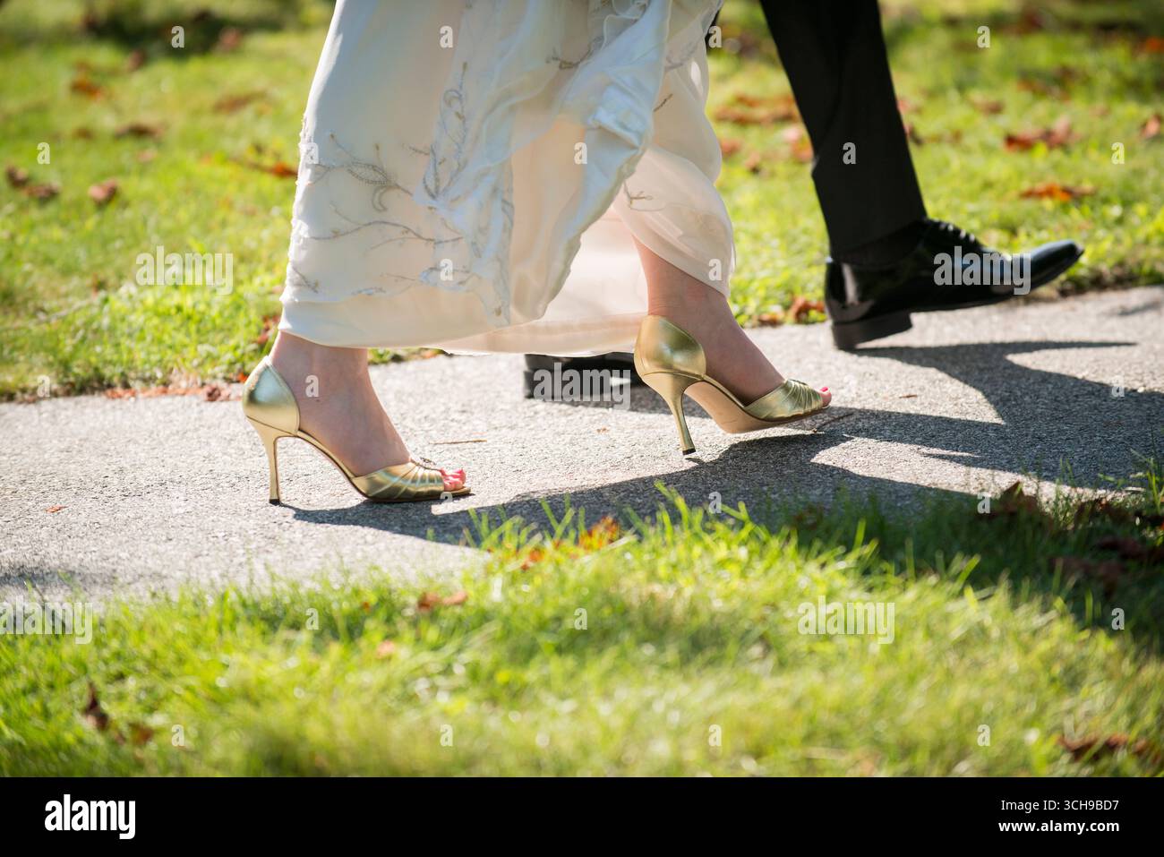 Mariée et mariée marchant à l'extérieur dans une tenue de mariage formelle Banque D'Images