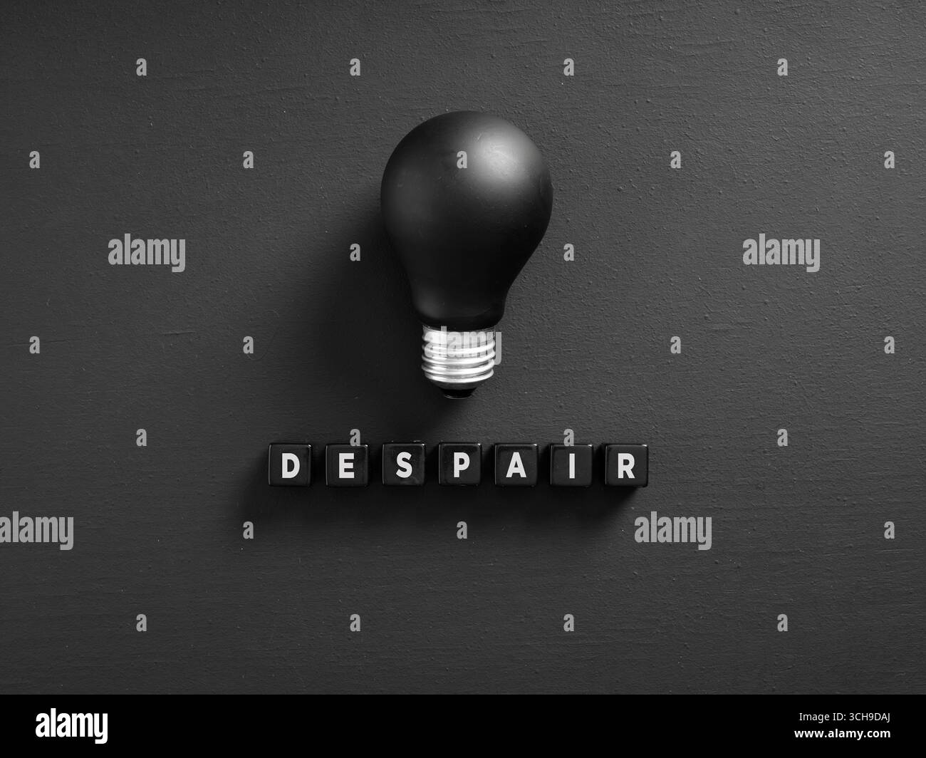 Ampoule noire et texte de désespoir sur fond sombre représentant le manque d'idées et de créativité Banque D'Images