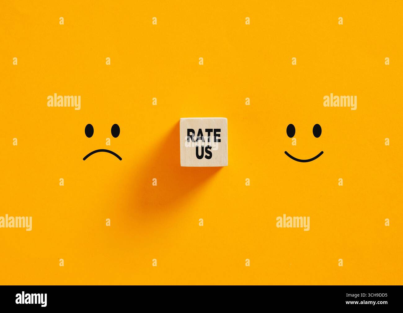 Cube en bois montrant le message de taux entre les emojis heureux et triste visage sur fond jaune Banque D'Images Cube en bois montrant le message de taux entre les emojis heureux et triste visage sur fond jaune Banque D'Images