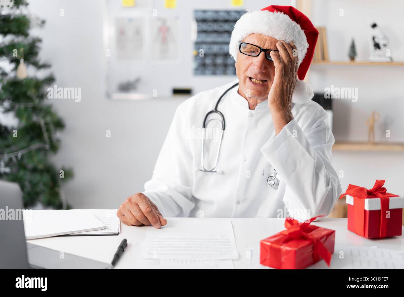 Médecin âgé senior à Santa Hat sur le quart de travail la veille de noël avec un geste épique d'omg erroné. copier l'espace Banque D'Images