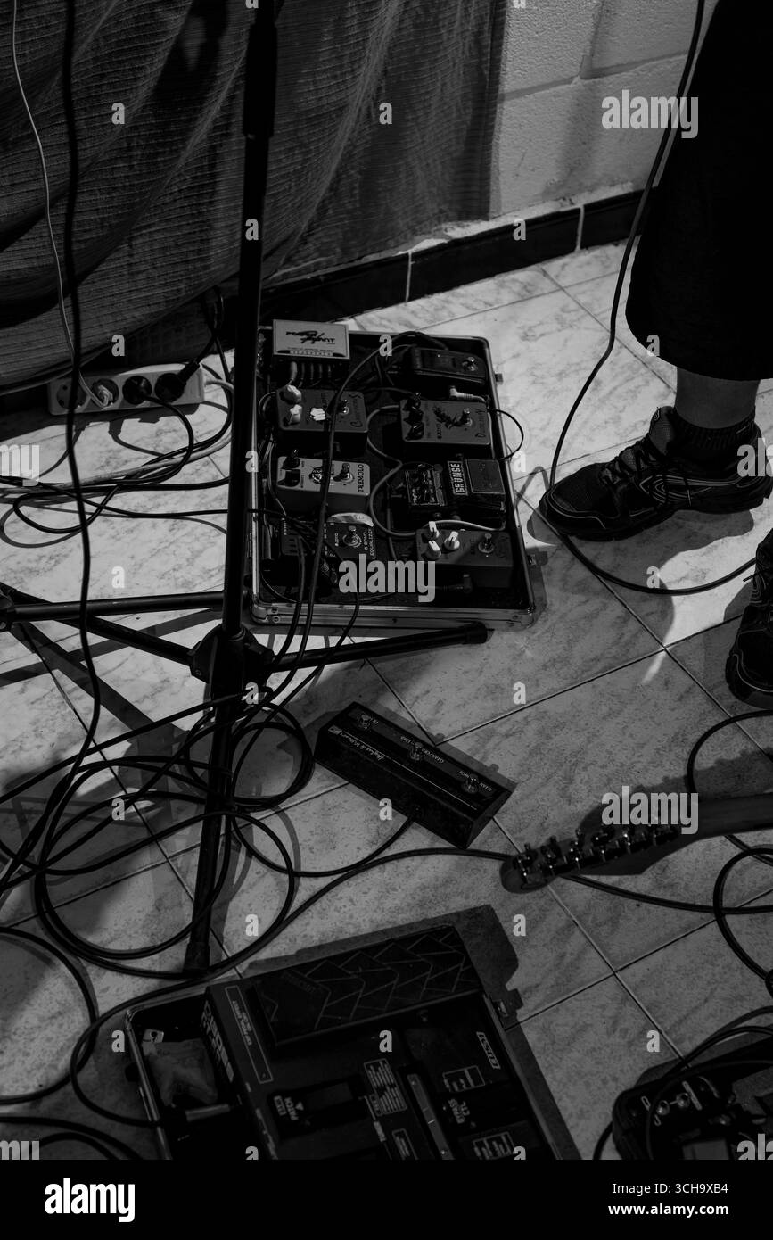 en la imagen podemos ver una pedalera intrumental para guitarra, cables y tripode,asi como los pies del musico Banque D'Images