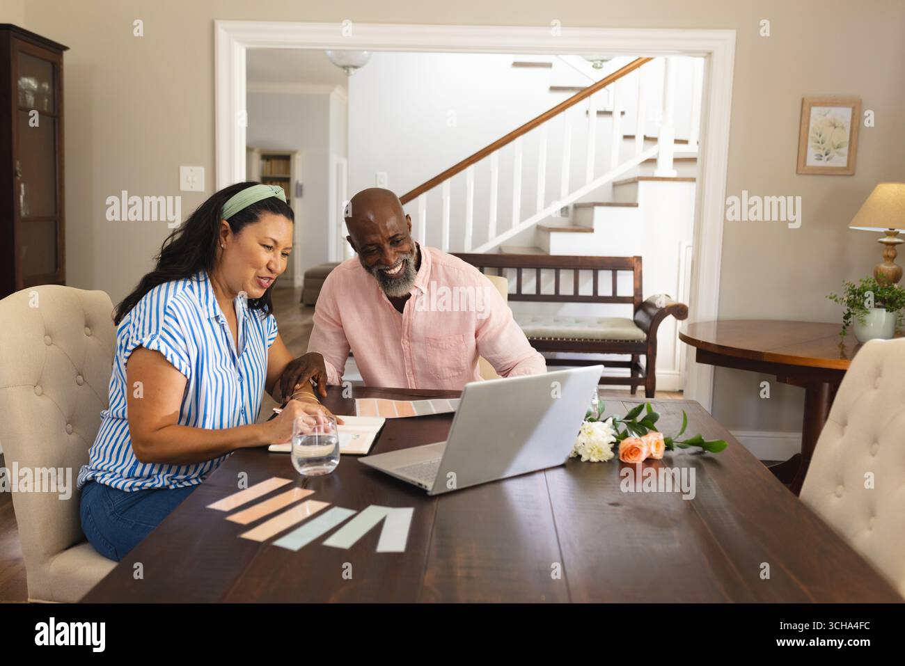 Couple senior afro-américain diversifié planifiant la rénovation de la maison en utilisant un ordinateur portable à la table à manger. Amélioration de la maison, technologie, travail d'équipe, brainstorming, l Banque D'Images
