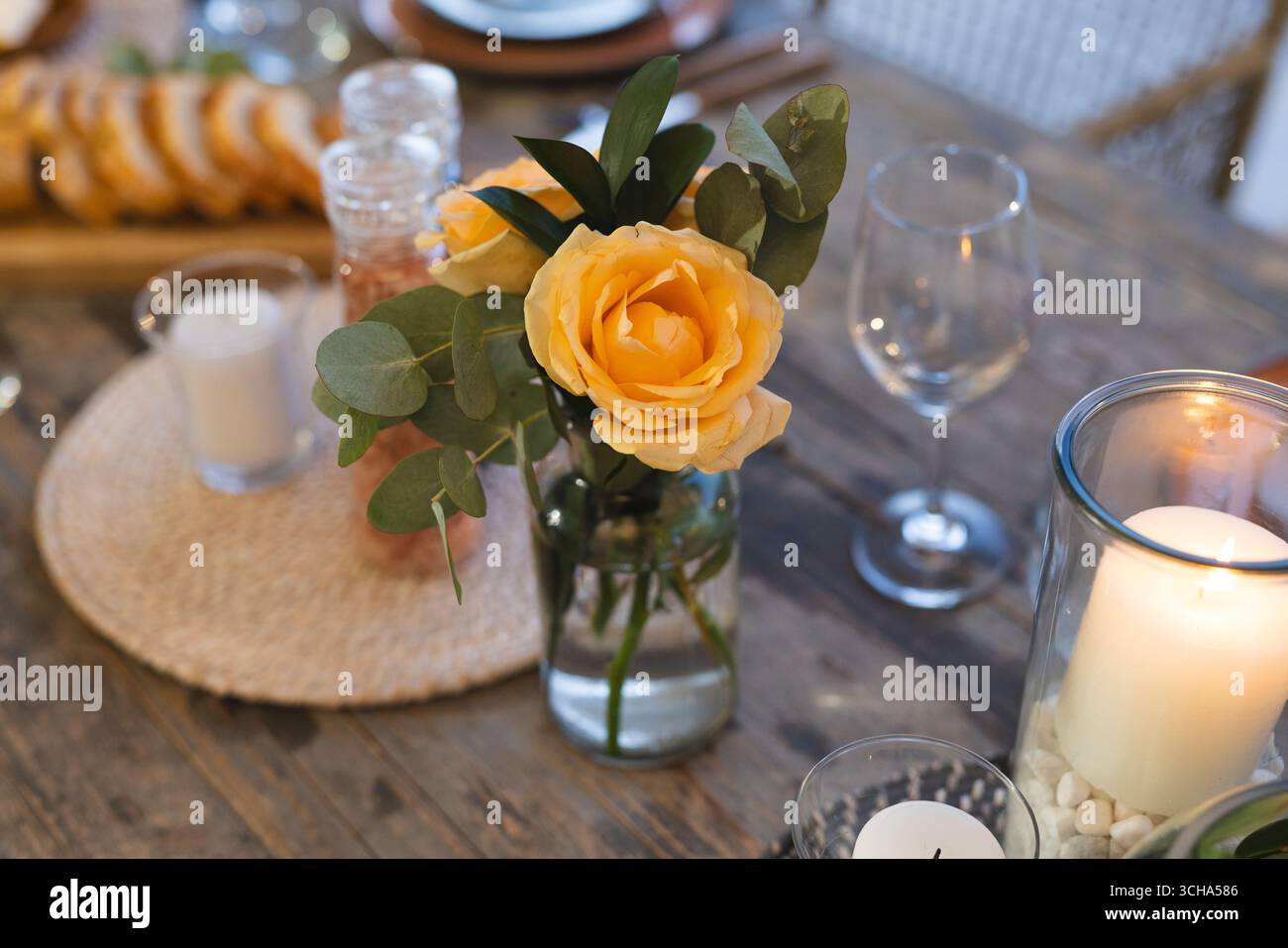 Roses jaunes dans un vase décorant une table à manger élégante pour le dîner de célébration senior. Fleurs, table, floral, arrangement, festivité, luxe Banque D'Images