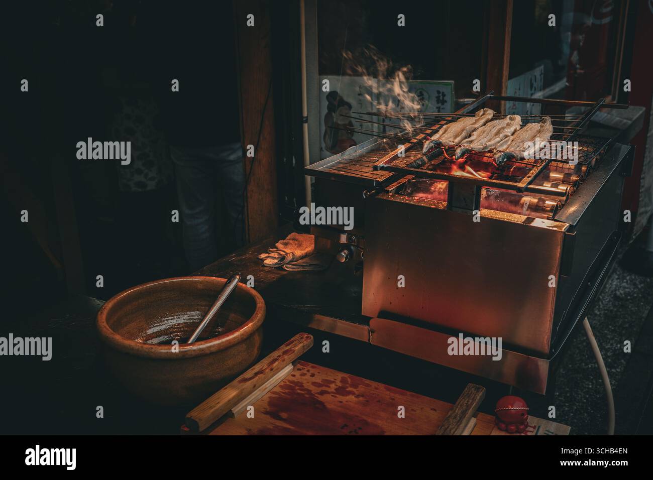 Anguille grillée cuisant au feu de charbon de bois dans un stand traditionnel japonais de nourriture de rue à Kyoto, au Japon. Banque D'Images
