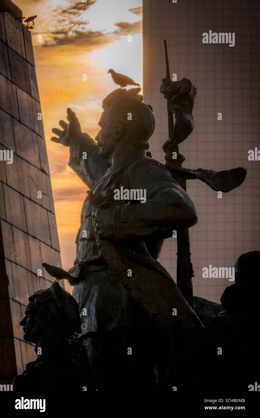 Monument aux combattants pour le pouvoir soviétique sur la place centrale de Vladivostok, Russie, statues en bronze contre la lumière dramatique du coucher du soleil (photo verticale). Banque D'Images