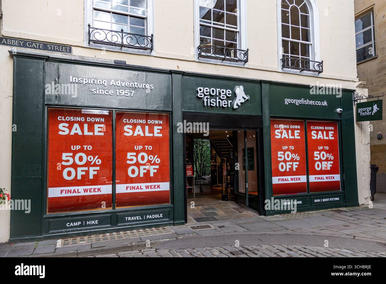 Vue avant du magasin extérieur George Fisher avec de grandes enseignes de vente offrant jusqu'à 50 % de rabais dans le cadre d'une vente de clôture Abbey Gate Street Bath Banque D'Images