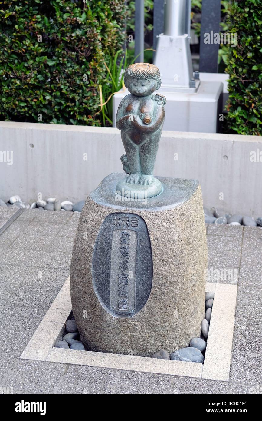 Statue d'une mère kappa et d'enfants frottés pour une grossesse saine, l'accouchement, un enfant, un fils ou une fille au sanctuaire Suitengu à Tokyo, au Japon. Banque D'Images