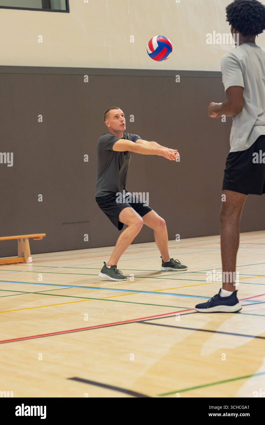 Divers coéquipiers masculins exécutant la bosse de l'avant-bras sur un terrain de gymnastique avec volley-ball et banc, espace de copie. Athlètes, travail d'équipe, fitness, actif, sport, concurrente Banque D'Images Divers coéquipiers masculins exécutant la bosse de l'avant-bras sur un terrain de gymnastique avec volley-ball et banc, espace de copie. Athlètes, travail d'équipe, fitness, actif, sport, concurrente Banque D'Images