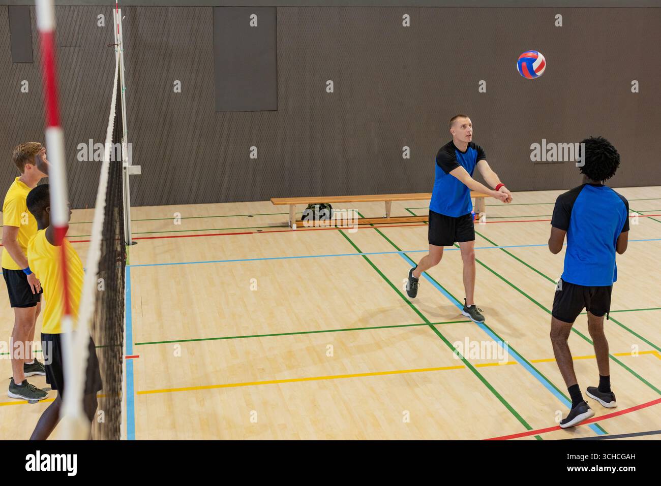 Divers athlètes masculins sautant au filet et recevant du volleyball volant sur un terrain de gymnase, espace de copie. Athlétisme, sport d'équipe, compétition, arène intérieure, Banque D'Images Divers athlètes masculins sautant au filet et recevant du volleyball volant sur un terrain de gymnase, espace de copie. Athlétisme, sport d'équipe, compétition, arène intérieure, Banque D'Images