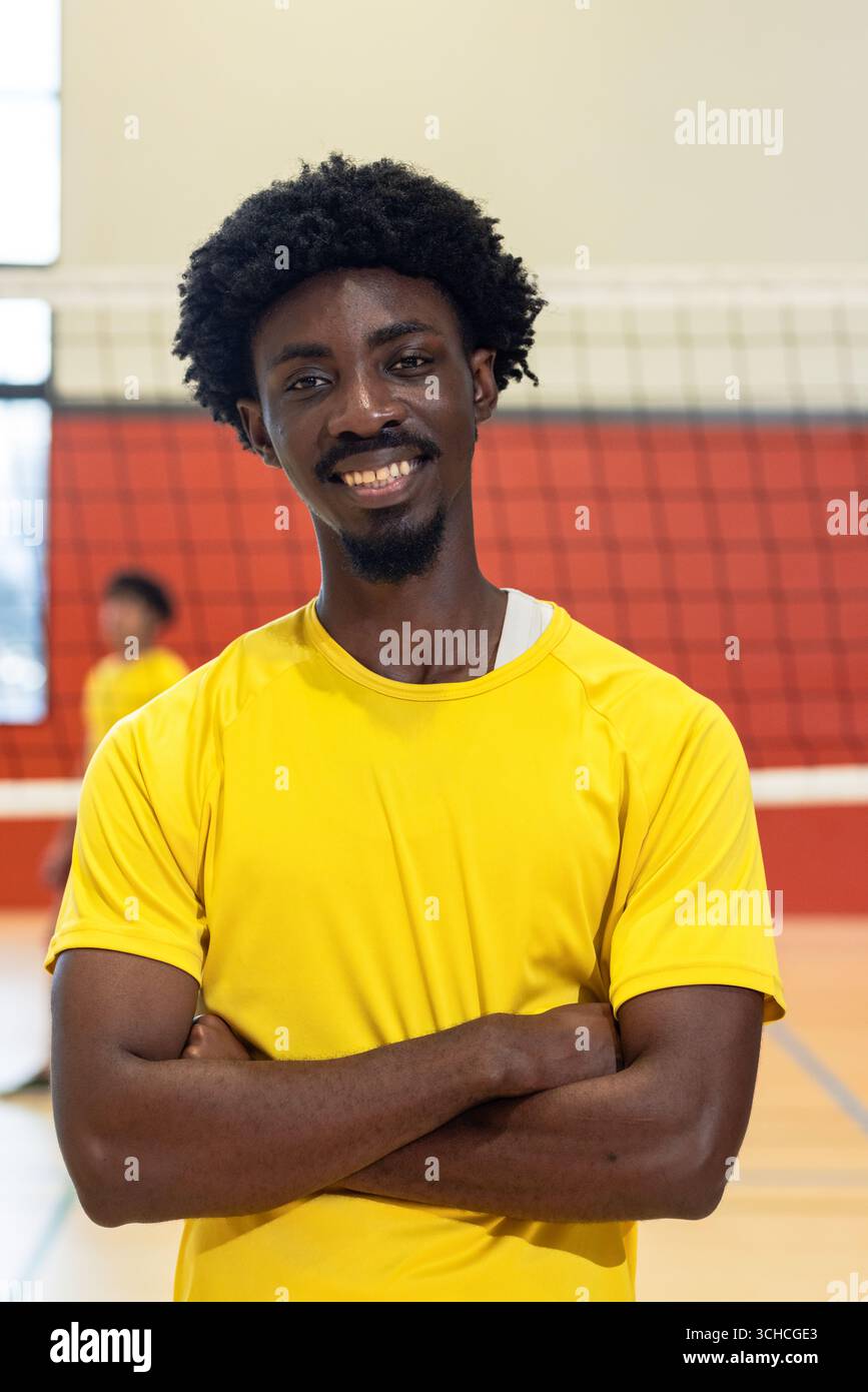 Coéquipiers afro-américains en maillot jaune posant les bras croisés sur le terrain de gymnastique montrant le filet. Athlète, travail d'équipe, esprit sportif, compétition, vib Banque D'Images Coéquipiers afro-américains en maillot jaune posant les bras croisés sur le terrain de gymnastique montrant le filet. Athlète, travail d'équipe, esprit sportif, compétition, vib Banque D'Images