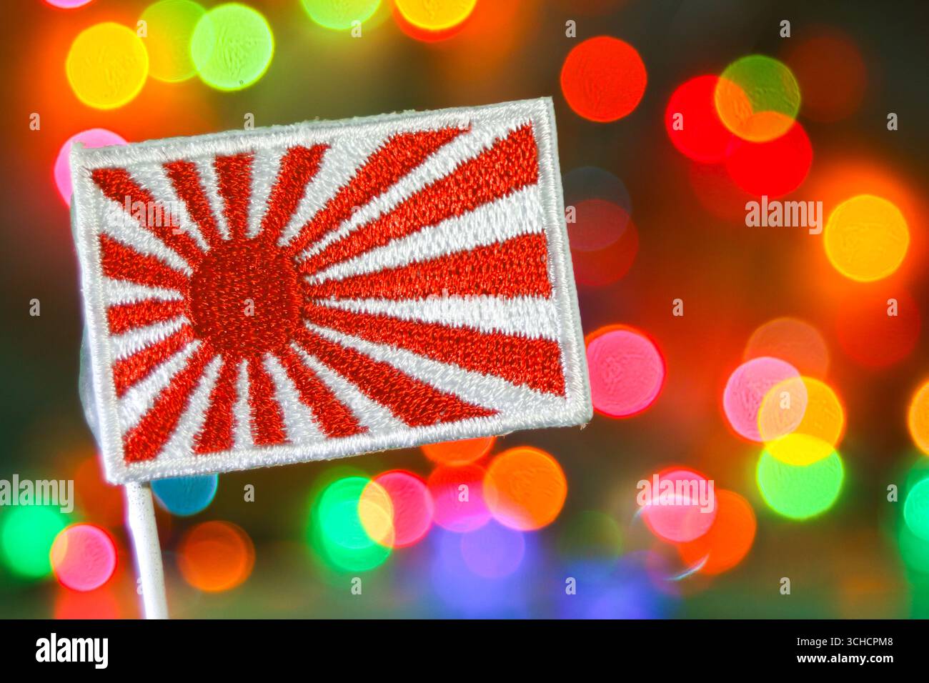 Broderie de drapeau Japan Rising Sun avec feux d'artifice bokeh arc-en-ciel, symbolisant le patrimoine, la célébration et l'esprit du nouvel an. Banque D'Images