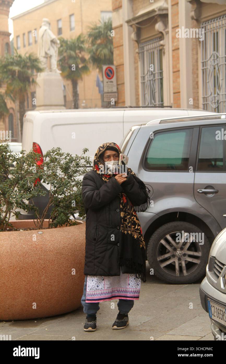 Femme âgée Musllim dans une rue en Italie parlant sur un téléphone portable Banque D'Images