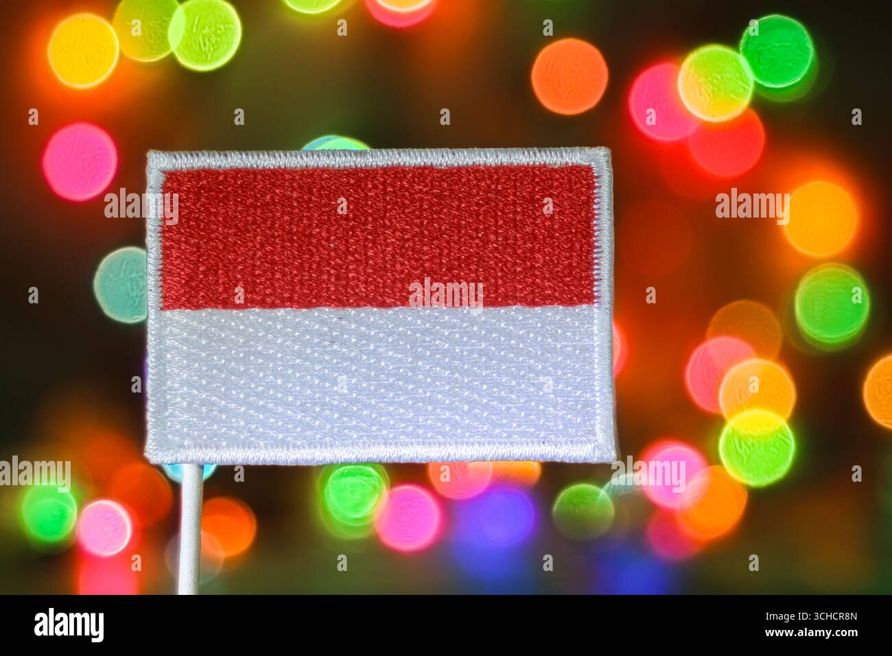 Drapeau indonésien brodé avec fond de feux d'artifice bokeh arc-en-ciel, symbolisant la célébration du nouvel an, l'indépendance et l'esprit patriotique des fêtes. Banque D'Images