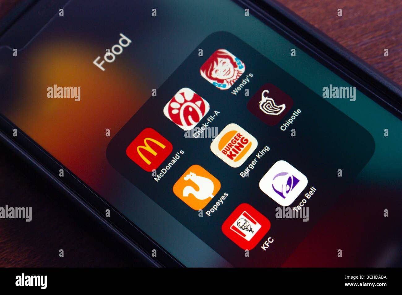 L'écran du smartphone affiche les principales applications de restauration rapide (McDonald's, Chick-fil-A, Wendy's, Popeyes, Burger King, Chipotle, KFC et Taco Bell). Banque D'Images
